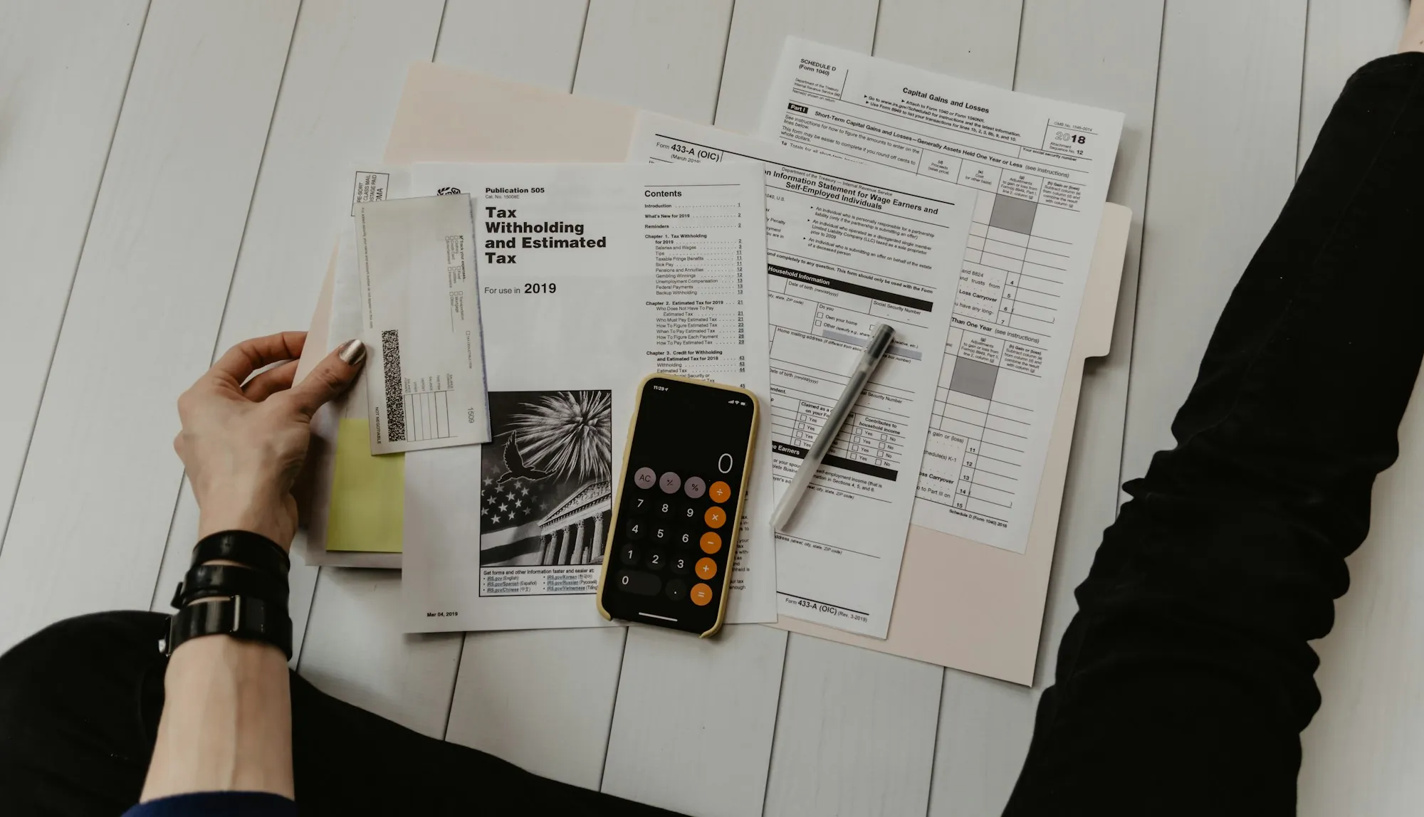 Person going over financial paperwork with a calculator
