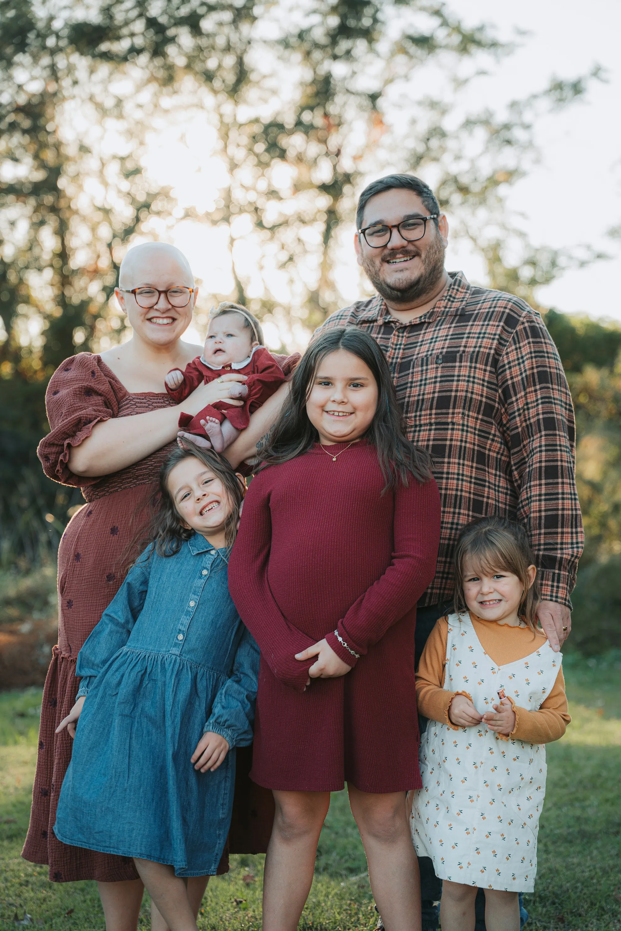 Family with three daughters posing outdoors